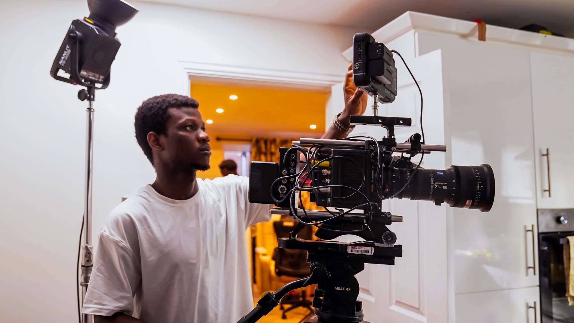 Favour Amuele adjusting a cinema camera on set